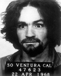 Black and white police mugshot of Charles Manson facing the camera.