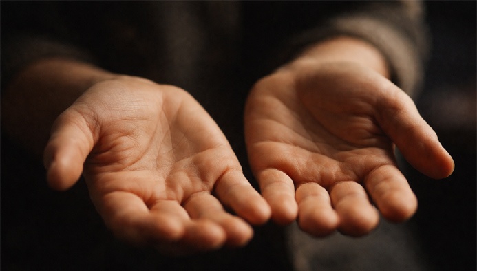 Hands held palm-up used in aura reading practices and subtle energy perception.