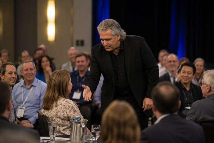 Mike Lamp performer leaning toward a seated audience member during a corporate mentalism show