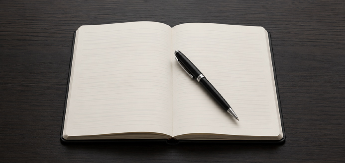 Open notebook with pen on a desk representing questions to ask when booking entertainment for events